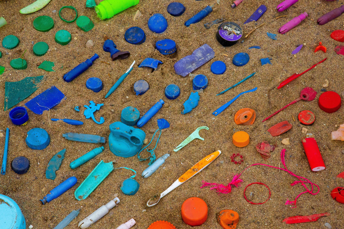Colourful plastic waste scattered on a sandy beach, highlighting the environmental impact of single-use plastics and the need for sustainable alternatives.
