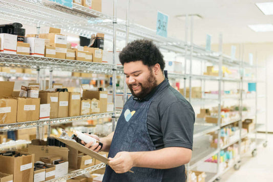 Proud news 🙏 Supporting Social Entreprise with new partnership! A worker in a warehouse reviewing items.