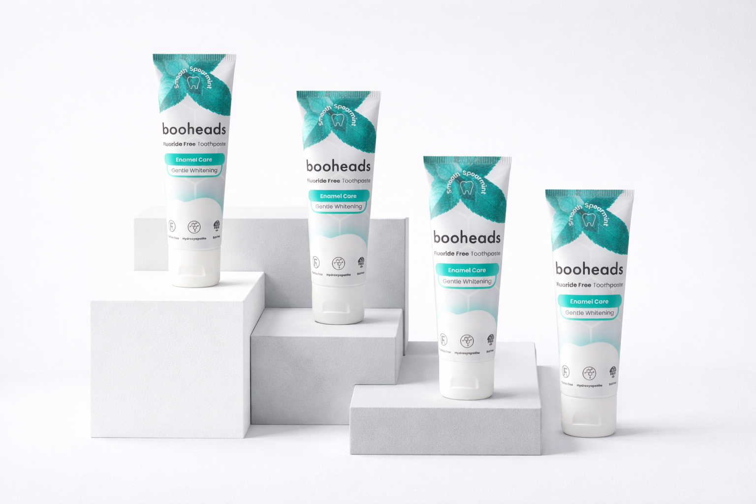 Four booheads fluoride-free toothpaste tubes displayed on white blocks