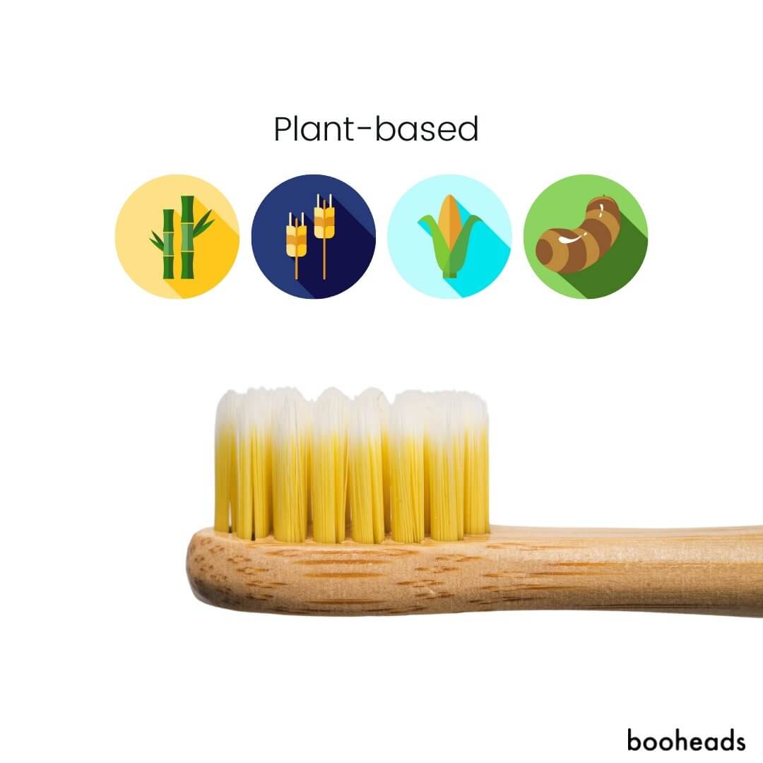 Close-up of yellow bristles on a booheads bamboo toothbrush head with plant-based material icons