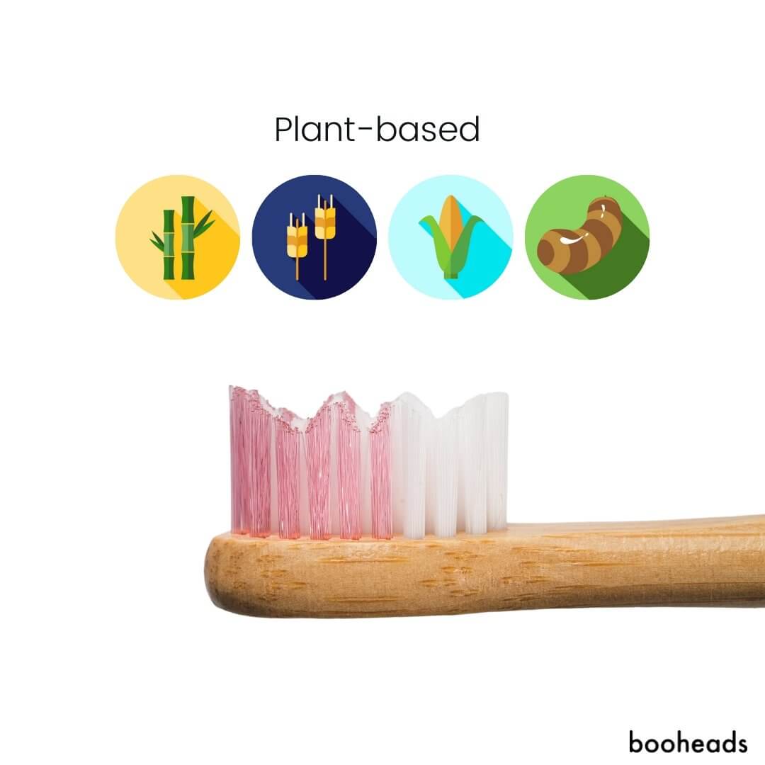 Bamboo toothbrush with plant-based materials icons and 'booheads' branding.